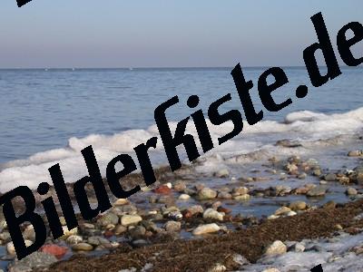 Schnee und Steine am Strand