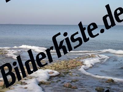 Schnee und Steine am Strand