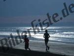 Mamma e figlio che corrono in riva al mare