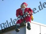 Weihnachtsmann sitzt auf einer Dachecke