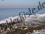 Neve e pietre in riva al mare