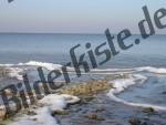 Schnee und Steine am Strand